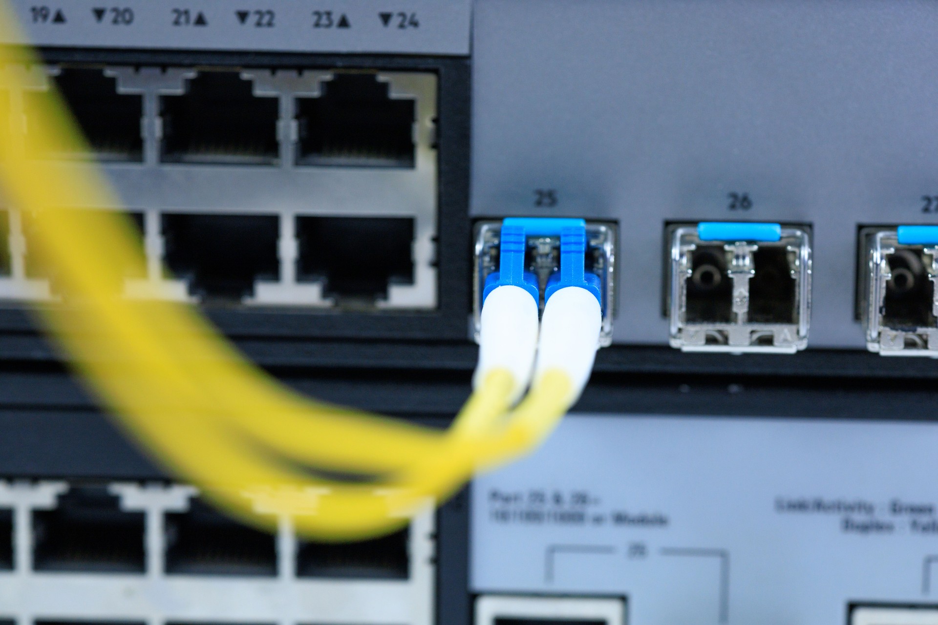 Yellow coiled fiber optic patch cord with blue connectors SFP modules are essential for high-speed data transmission over fiber optic networks.