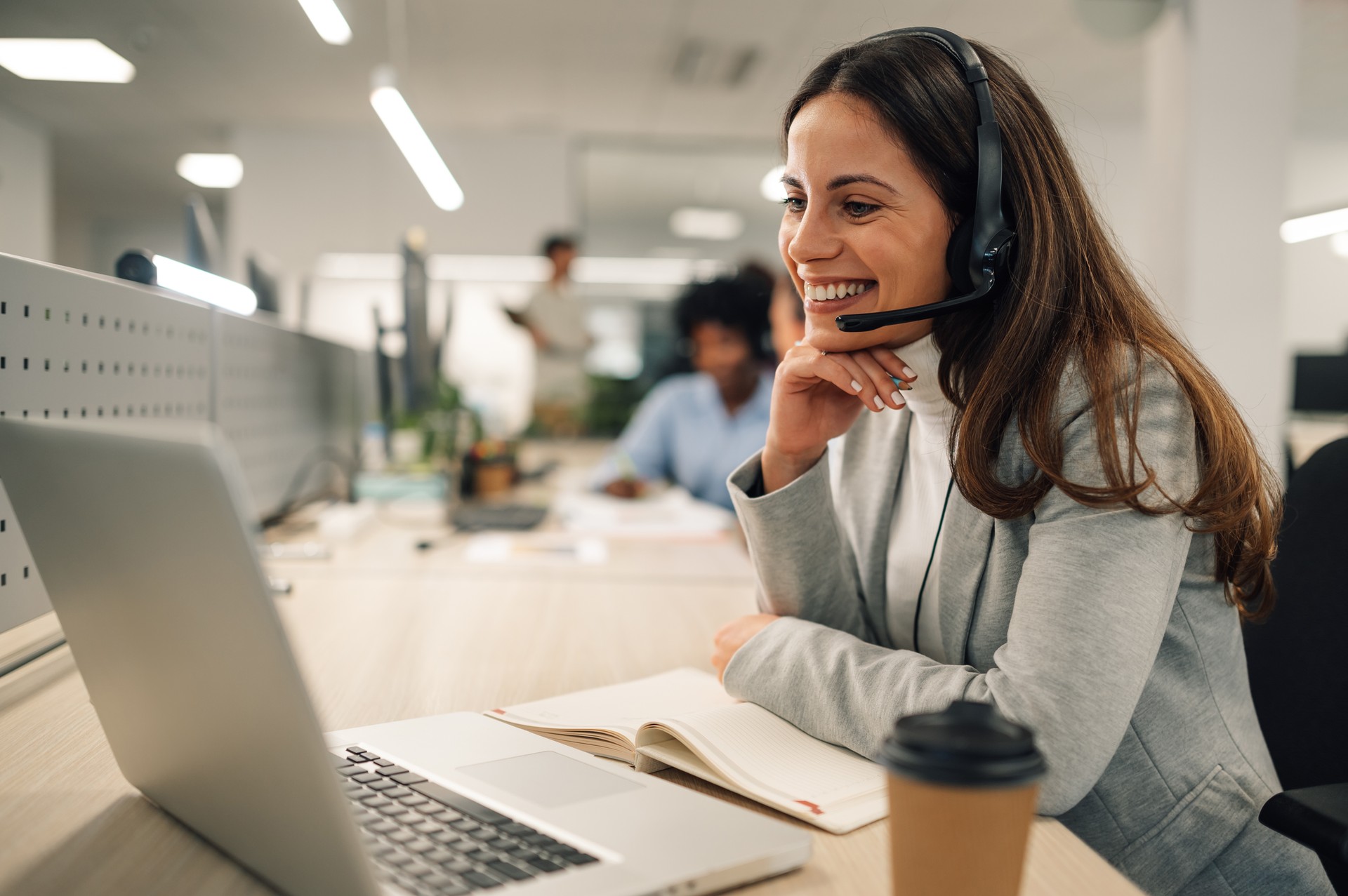 A friendly customer support agent is talking with client at call center.